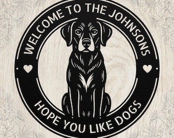 May include: A circular black metal sign featuring a central illustration of a sitting dog. The text reads "WELCOME TO THE JOHNSONS" along the top and "HOPE YOU LIKE DOGS" along the bottom, with a small heart icon on the left and right sides.