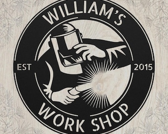 May include: A circular black metal sign featuring a central graphic of a person wearing a welding helmet and holding a welding torch. The text "WILLIAM'S" is arched at the top, "WORK SHOP" at the bottom, and "EST 2015" on the sides.