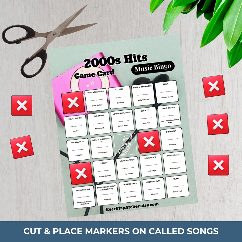 May include: A 2000s Hits Music Bingo game card with red X markers, a pink MP3 player, and scissors. The card features song titles and artist names. Text on the card reads "Cut & Place Markers on Called Songs" and "EverPlayAtelier.etsy.com."