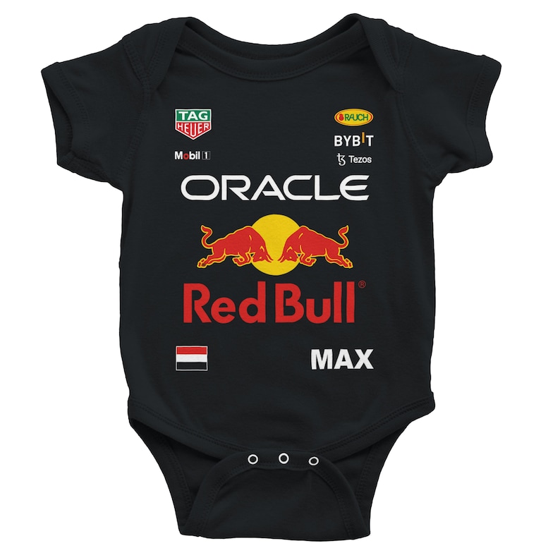 Puede incluir: Body de beb&eacute; negro con el logo de Red Bull Racing. El body presenta el logo de Oracle, el logo de Red Bull y la palabra "MAX". Logos adicionales incluyen Tag Heuer, Rauch y Bybit.