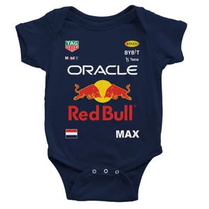 Könnte beinhalten: Marineblauer Baby-Body mit dem Red Bull-Logo, Oracle und Sponsorenlogos. Der Body hat kurze Ärmel und drei Druckknöpfe am unteren Saum. Der Schriftzug "MAX" ist unten rechts aufgedruckt.