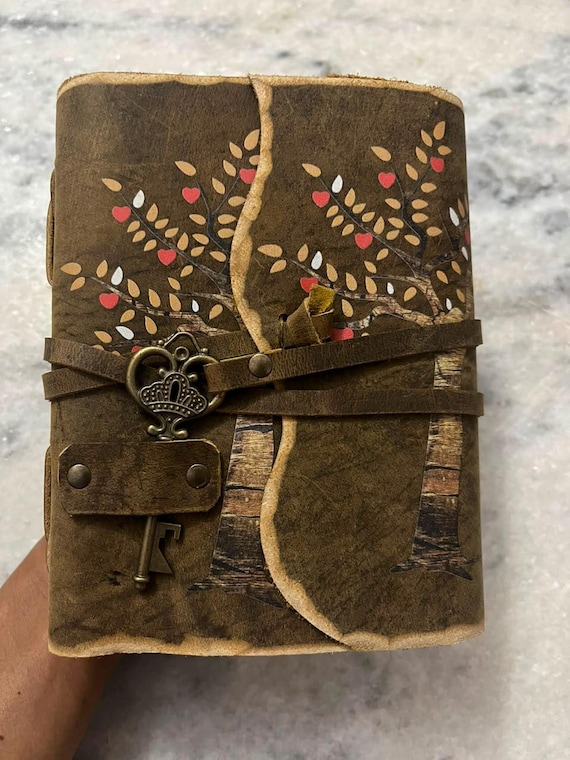 A hand-stitched leather journal with deckle-edge paper AND an antique skeleton key closure — the kind of object that feels like it belongs in a wizard's study.