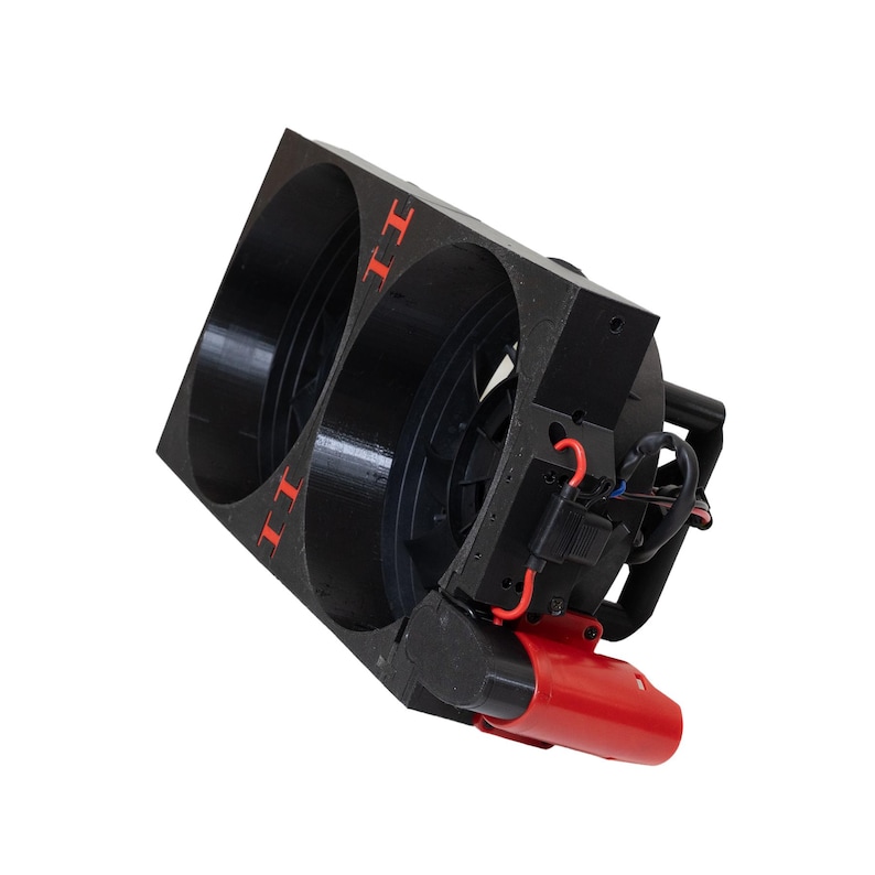May include: A black, rectangular device with two circular openings. The device has red accents, including the letters "II" and a red cylindrical component. Wires and other components are visible.
