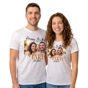 Op de afbeelding: Witte T-shirts met een familiefoto, de woorden "Happy Birthday" en de naam "MARK" in oranje, met het jaartal "2026" eronder. De shirts worden gedragen door een man en een vrouw.