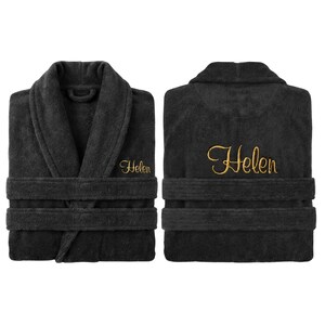 May include: Two views of a dark gray plush bathrobe with a shawl collar and belt. The name "Helen" is embroidered in gold script on the chest and back. The robe has wide sleeves and a thick belt.