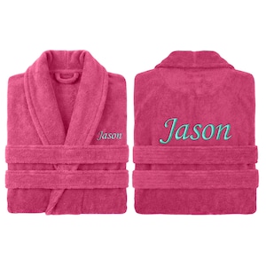 May include: A magenta terry cloth robe with the name "Jason" embroidered in teal on the front and back. The robe has a shawl collar, a waist tie, and two front pockets. The robe is displayed from the front and back.