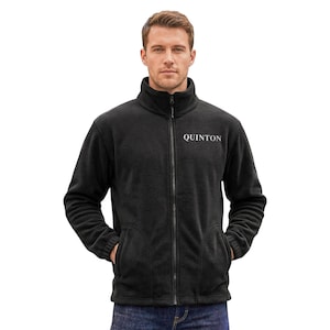 Könnte beinhalten: Schwarze Fleecejacke mit hohem Kragen und durchgehendem Reißverschluss. Die Jacke hat zwei Vordertaschen und den Schriftzug "QUINTON" auf der Brust. Das Model trägt die Jacke.