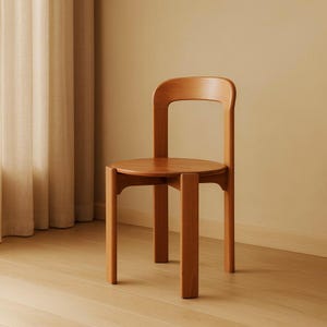 Op de afbeelding: Een houten stoel met een ronde zitting en een gebogen rugleuning. De stoel is gemaakt van lichtgekleurd hout en heeft een eenvoudig, modern ontwerp. De poten van de stoel zijn vierkant en stevig. De stoel staat tegen een neutrale achtergrond.