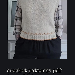 May include: Cream-colored crochet vest with a decorative border. The vest is worn over a plaid shirt and black pants. The image includes the text "crochet patterns pdf in english".