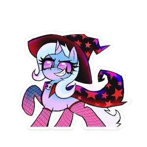 May include: A sticker featuring a cartoon pony with a witch hat and cape. The pony has a light blue body, pink eyes, and a mischievous grin. The hat is black with red stars, and the cape is red and black.