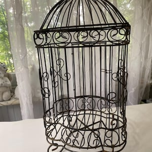 A black decorative ornate birdcage with patina, a table centerpiece, many uses