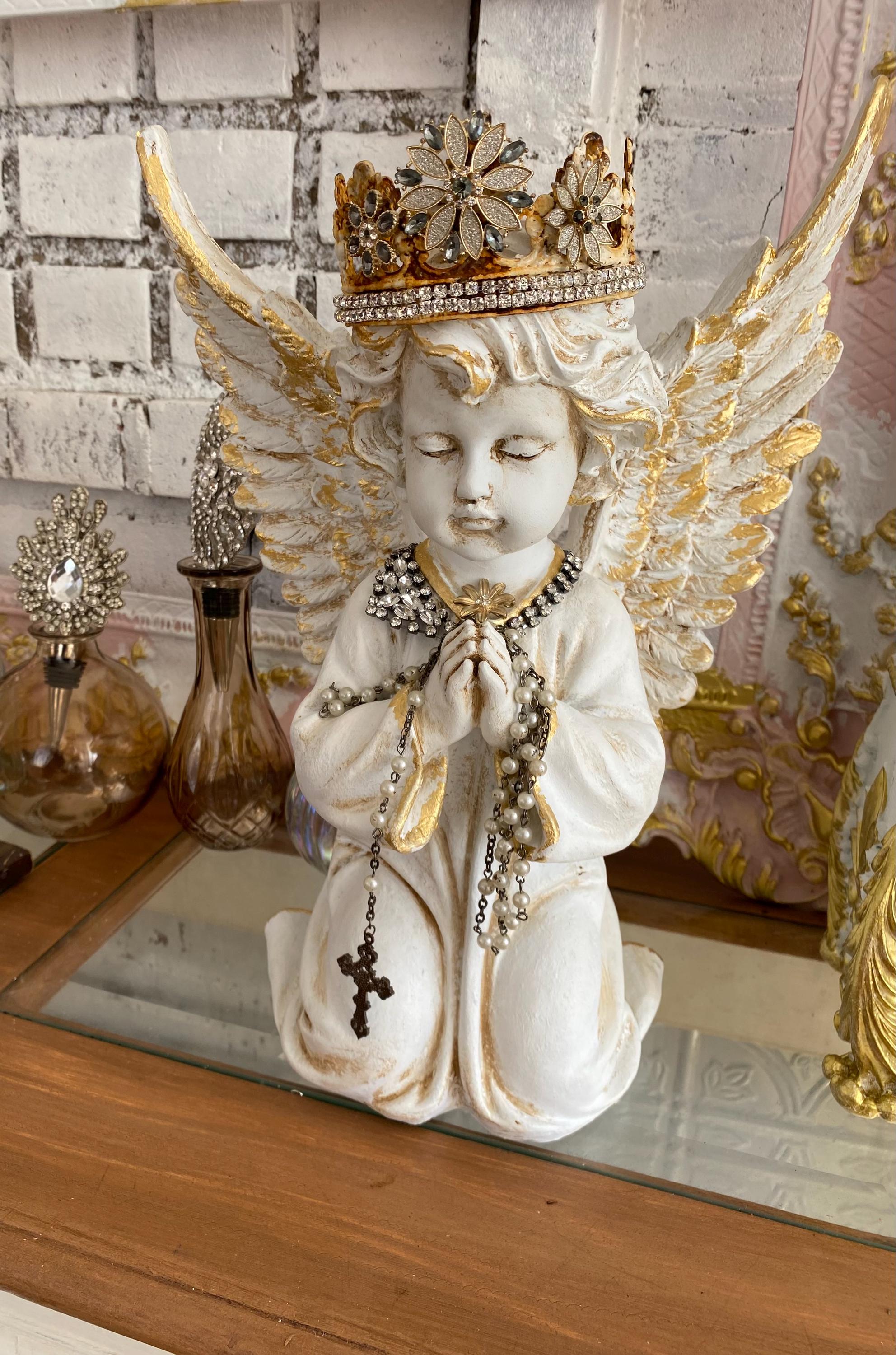 A large winged cherub statue, gold foil, rosary beads, crowned cherub, home decor