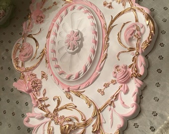 A large baroque ceiling medallion, pink, white and hand painted gold rococo medallion