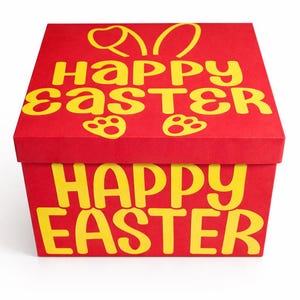 May include: A red box with a yellow "Happy Easter" message and bunny ears on the lid. The box also features paw prints. The box is a festive item for Easter.