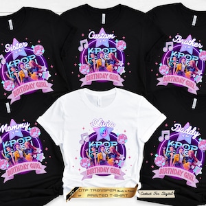 May include: A collection of black and white t-shirts featuring a K-pop themed graphic. The design includes three illustrated figures, a purple neon circle, disco balls, musical notes, and stars. Text includes phrases like Birthday Girl.
