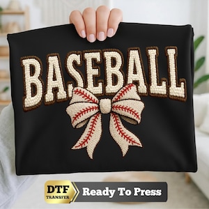 May include: A black fabric transfer featuring the word BASEBALL in large, cream-colored, textured varsity-style letters with a dark brown outline. Below the text is a large cream-colored bow with red stitching resembling a baseball seam.