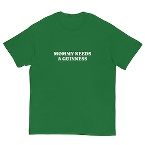 May include: Green t-shirt with the white text "MOMMY NEEDS A GUINNESS". The shirt is made of a soft material and has a crew neck. A casual top for everyday wear.
