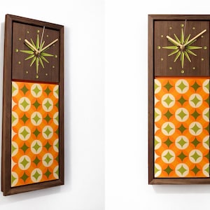 Puede incluir: Un reloj de pared rectangular con un marco de madera marrón oscuro. La sección superior presenta una esfera de reloj en forma de estrella con manecillas doradas y un diseño de estrella verde. La sección inferior tiene un patrón geométrico naranja y verde.