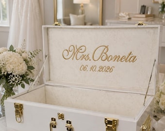 May include: A white rectangular keepsake box with gold-toned metal latches and a handle. The interior lid features the gold-colored text Mrs. Boneta and the date 06.10.2026. The box has a smooth finish and is open to reveal a light-colored interior.