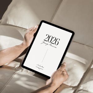 Puede incluir: Una tableta digital que muestra una pantalla blanca con el texto negro 2026 Yearly Planner, una línea vertical y la firma Studio Alac An Original Creation 4OHO en la parte inferior. El dispositivo tiene un marco negro fino y esquinas redondeadas.