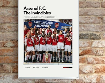 May include: A framed poster featuring the Arsenal F.C. team, celebrating their Premier League Championship win in 2003/2004. The poster includes the text "The Invincibles" and details of their season: 26 wins, 12 draws, and 0 losses.