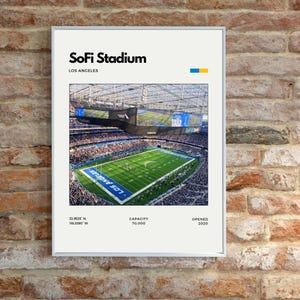Puede incluir: Impresión enmarcada del estadio SoFi en Los Ángeles. La imagen muestra una vista aérea del campo y las gradas del estadio. El texto en la parte superior dice "SoFi Stadium" y "Los Ángeles". Texto adicional incluye coordenadas, capacidad y el año 2020.