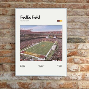 May include: A framed print of FedEx Field in Washington. The image shows a full stadium during a game. The print includes the stadium's name, location, capacity, and opening year.