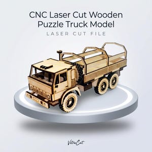 Puede incluir: Un modelo de camión rompecabezas de madera cortado con láser CNC. El modelo está hecho de madera de color claro y presenta cortes detallados. El camión tiene una cabina, una plataforma de carga y seis ruedas. El texto "CNC Laser Cut Wooden Puzzle Truck Model" y "Laser Cut File" son visibles.