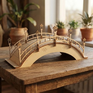 Könnte beinhalten: Ein Holzmodell einer Brücke mit gewölbten Stützen und dekorativen Straßenlaternen. Die Brücke hat ein detailliertes Design mit Geländern und einer strukturierten Oberfläche aus hellem Holz. Das Modell wird auf einem Holztisch präsentiert.