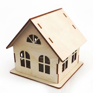 Op de afbeelding: Een houten huismodel met een lichtbruine afwerking. Het huis heeft een zadeldak, boogvensters en rechthoekige ramen. De randen van het dak en de basis zijn donkerder bruin. Het huis is ontworpen met sleuven voor montage.