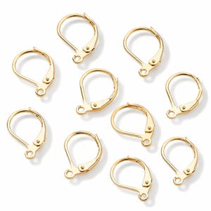 May include: A collection of nine gold-toned metal leverback earring findings. Each piece features a circular hoop design with a hinged closure mechanism and a small loop at the base for attaching jewellery components, arranged in a scattered pattern.