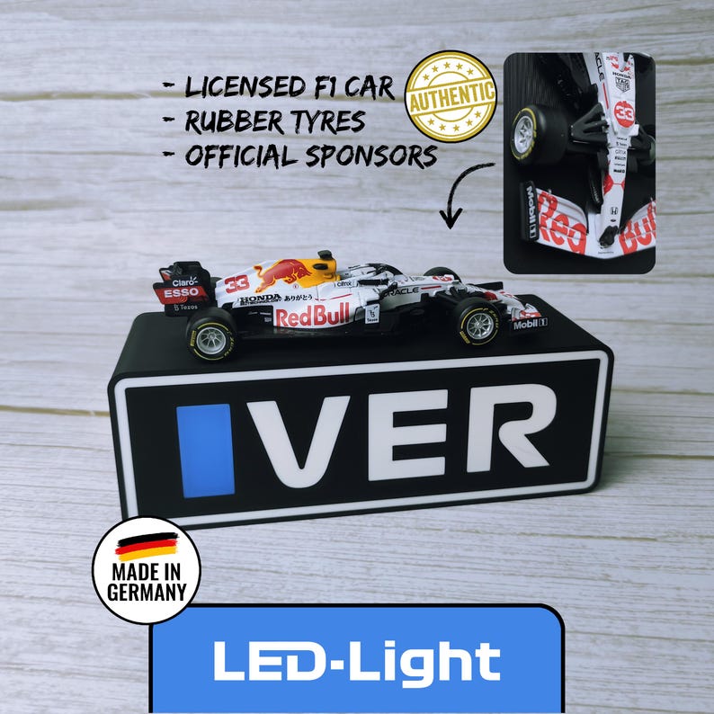 May include: A miniature Red Bull Formula 1 race car with the number 33, displayed on a black base with the word "VER". The car features sponsor logos and rubber tires. The image also includes the text "LED-Light" and "Made in Germany".