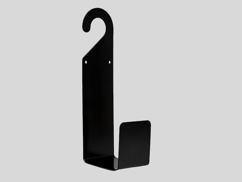 Puede incluir: Un perchero de pared de metal negro con un gancho curvo en la parte superior y una base rectangular. El perchero est&aacute; dise&ntilde;ado para colgar objetos y tiene una est&eacute;tica minimalista y moderna. El perchero es de metal.