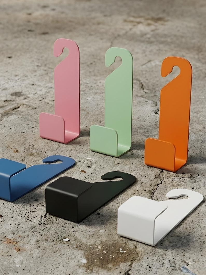Puede incluir: Colecci&oacute;n de ganchos met&aacute;licos coloridos en rosa, verde y naranja, con forma de gancho en la parte superior y base rectangular. Tambi&eacute;n hay ganchos adicionales en azul, negro y blanco. Estos ganchos est&aacute;n dise&ntilde;ados para colgar objetos.