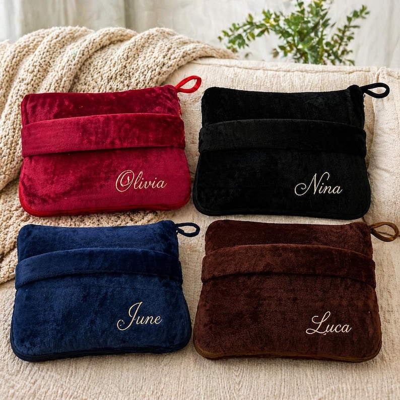 Puede incluir: Cuatro almohadas rectangulares de felpa en rojo, negro, azul marino y marr&oacute;n. Cada almohada tiene una banda a juego en el medio y un lazo en un lado. Los nombres "Olivia", "Nina", "June" y "Luca" est&aacute;n bordados en cada almohada.