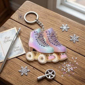 May include: A roller skate keychain with a pastel rainbow design, featuring the name "Sophia". The keychain has a silver chain and ring. Decorative snowflakes and a pen are also present on a wooden surface.