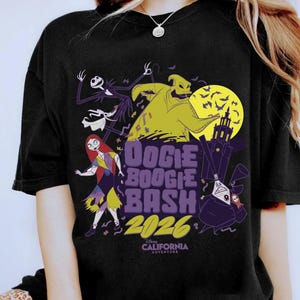 May include: Black t-shirt featuring characters from The Nightmare Before Christmas. The design includes Jack Skellington, Sally, Oogie Boogie, and the text "Oogie Boogie Bash 2026" with a California Adventure logo.