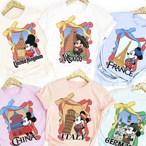 May include: A collection of t-shirts featuring Mickey Mouse in various travel-themed designs. Each shirt showcases a different country, including the United Kingdom, Mexico, France, China, Italy, and Germany, with corresponding landmarks and text.