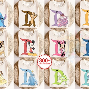 Peut inclure: Une collection de douze t-shirts couleur cr&egrave;me, chacun pr&eacute;sentant une grande lettre D de diff&eacute;rentes couleurs associ&eacute;e &agrave; un personnage de dessin anim&eacute;, dont Stitch, Chip, le Chat du Cheshire, Simba, Pocahontas, Mickey, Minnie, Captain America, Belle, Cendrillon, Mike Wazowski et Sulley.