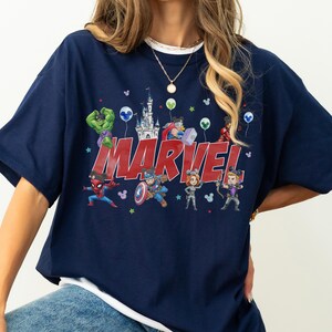 May include: A white ceramic mug with a black handle and the text "But First, Coffee" in a bold, black font. The mug is set against a neutral background, highlighting its simple design.