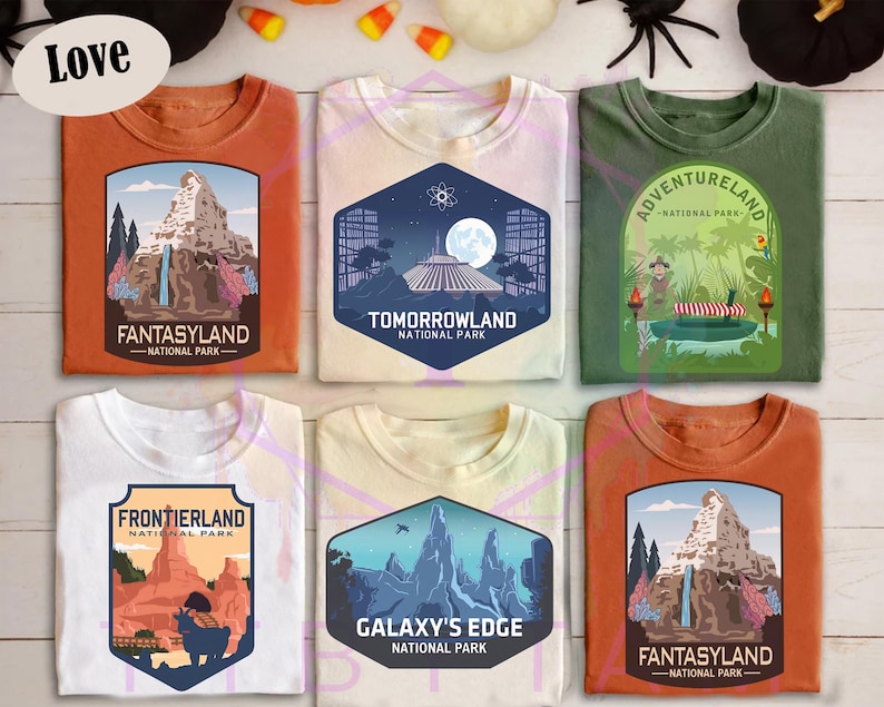 Puede incluir: Seis camisetas de diferentes colores, incluyendo naranja, blanco y verde. Cada camiseta presenta un dise&ntilde;o gr&aacute;fico diferente, incluyendo los textos "Fantasyland", "Tomorrowland", "Adventureland", "Frontierland" y "Galaxy's Edge".