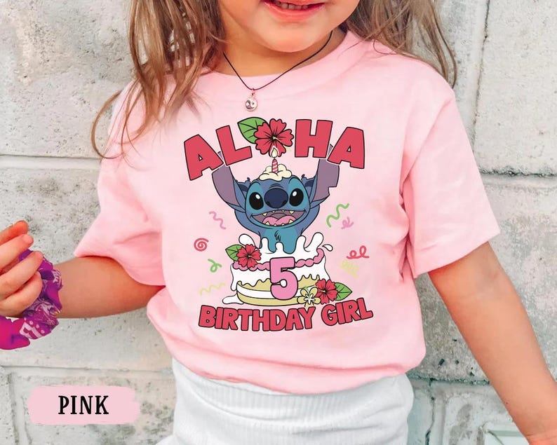 May include: Pink t-shirt featuring a graphic of Stitch from Lilo & Stitch on a birthday cake. The text "ALOHA" and "5 BIRTHDAY GIRL" are displayed in red. The shirt is a short-sleeved design.