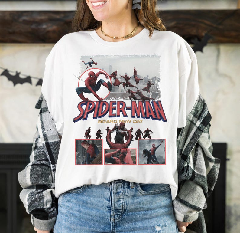May include: White t-shirt featuring a Spider-Man graphic. The design includes the words "SPIDER-MAN" in red and blue, with additional imagery of the superhero in action. The phrase "BRAND NEW DAY" is also present.