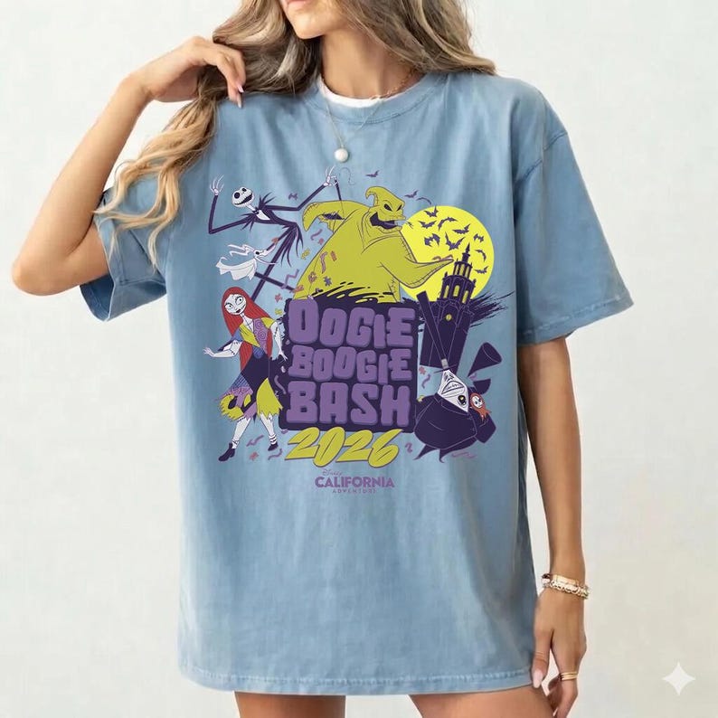 May include: A light blue t-shirt featuring a graphic design for the "Oogie Boogie Bash 2026" event in California. The design includes characters like Jack Skellington, Sally, and Oogie Boogie, with a spooky Halloween theme.