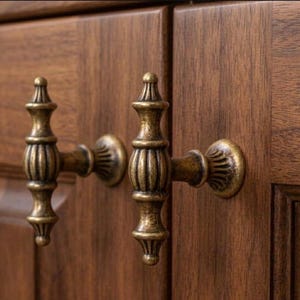 May include: A white ceramic mug with a black handle and the text "But First, Coffee" in a bold, black font. The mug is set against a blurred background, suggesting a cozy setting.