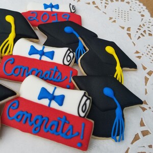 May include: A set of graduation cookies decorated with black graduation caps, red, white, and blue diplomas, and the words "Congrats!" and "2019".