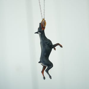 Ornamento da appendere all'auto: Doberman che cattura un giocattolo da mordere