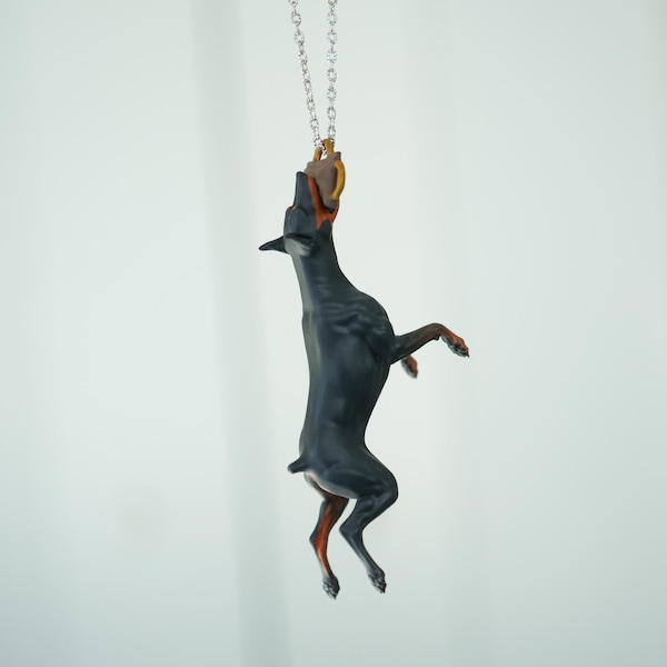 Adorno para coche: Doberman atrapando un juguete de mordedura de tirón