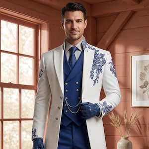 Puede incluir: Un abrigo largo blanco con bordados florales azules en las solapas y pu&ntilde;os, usado sobre un chaleco azul de doble botonadura con una cadena plateada, corbata azul, camisa clara, pantalones azules y guantes de cuero de color azul.