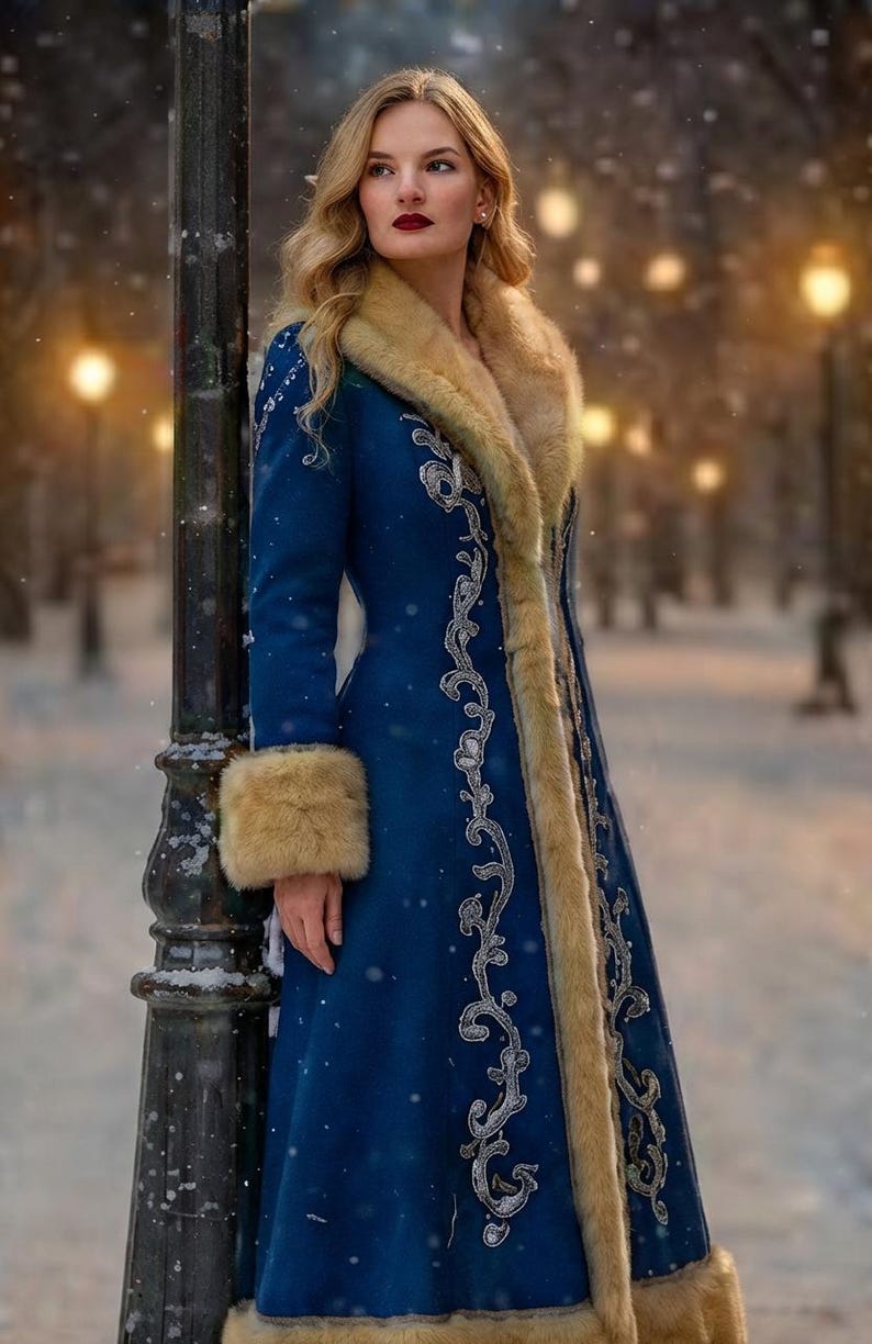 May include: A long, deep blue coat featuring a thick, light brown faux fur collar and matching fur cuffs. The coat is decorated with intricate silver-toned embroidery along the front opening and sleeves, extending down to the hemline.